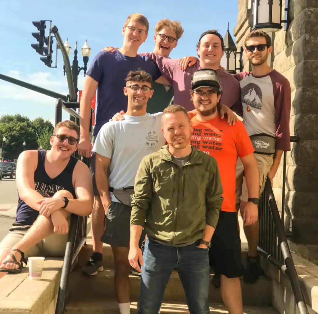 Group of college guys standing on stairs outside