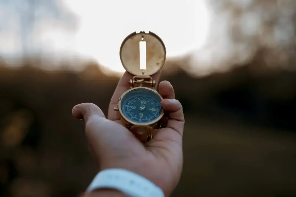 Closeup shot of a person holding a compass with a blurred background