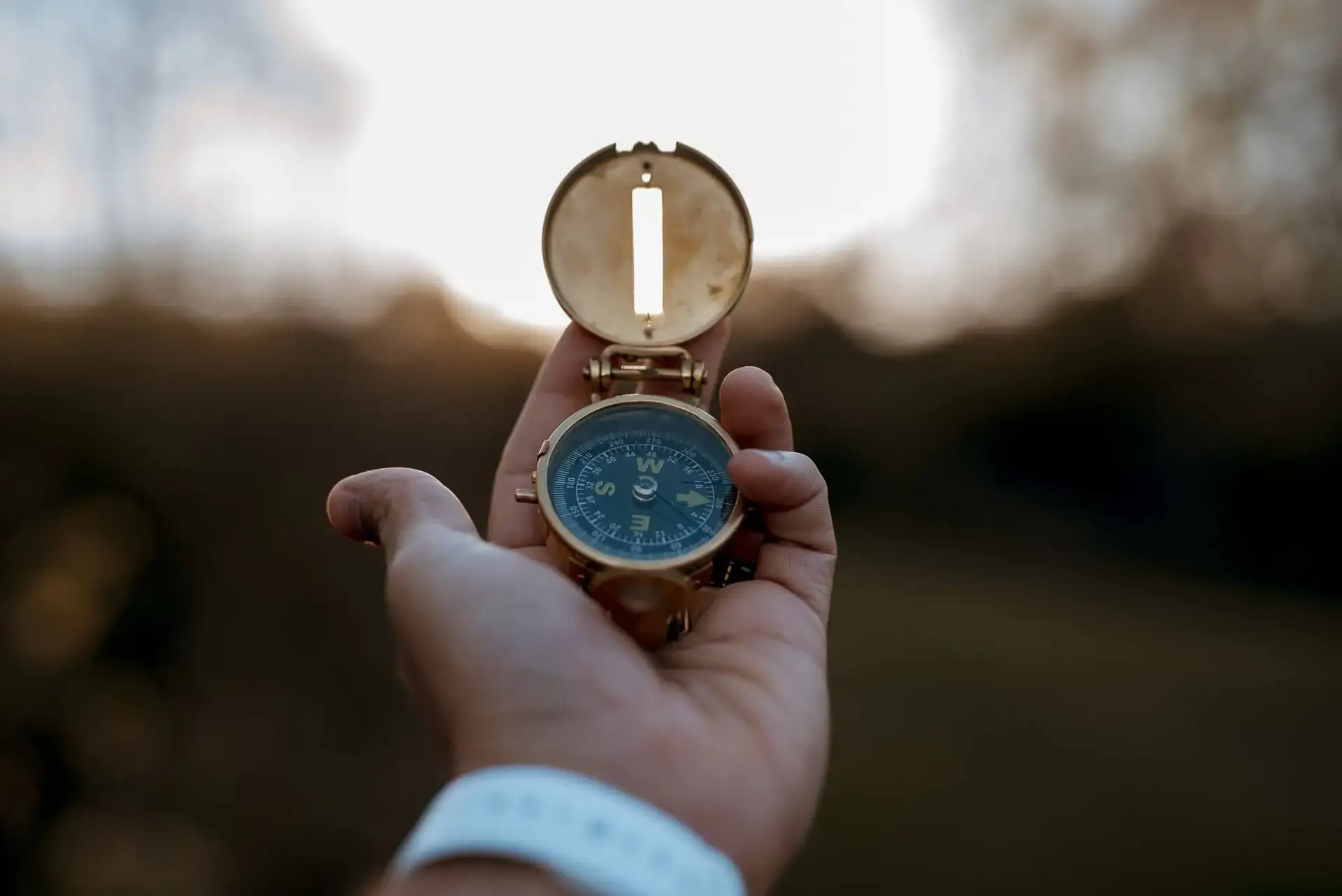 Closeup shot of a person holding a compass with a blurred background