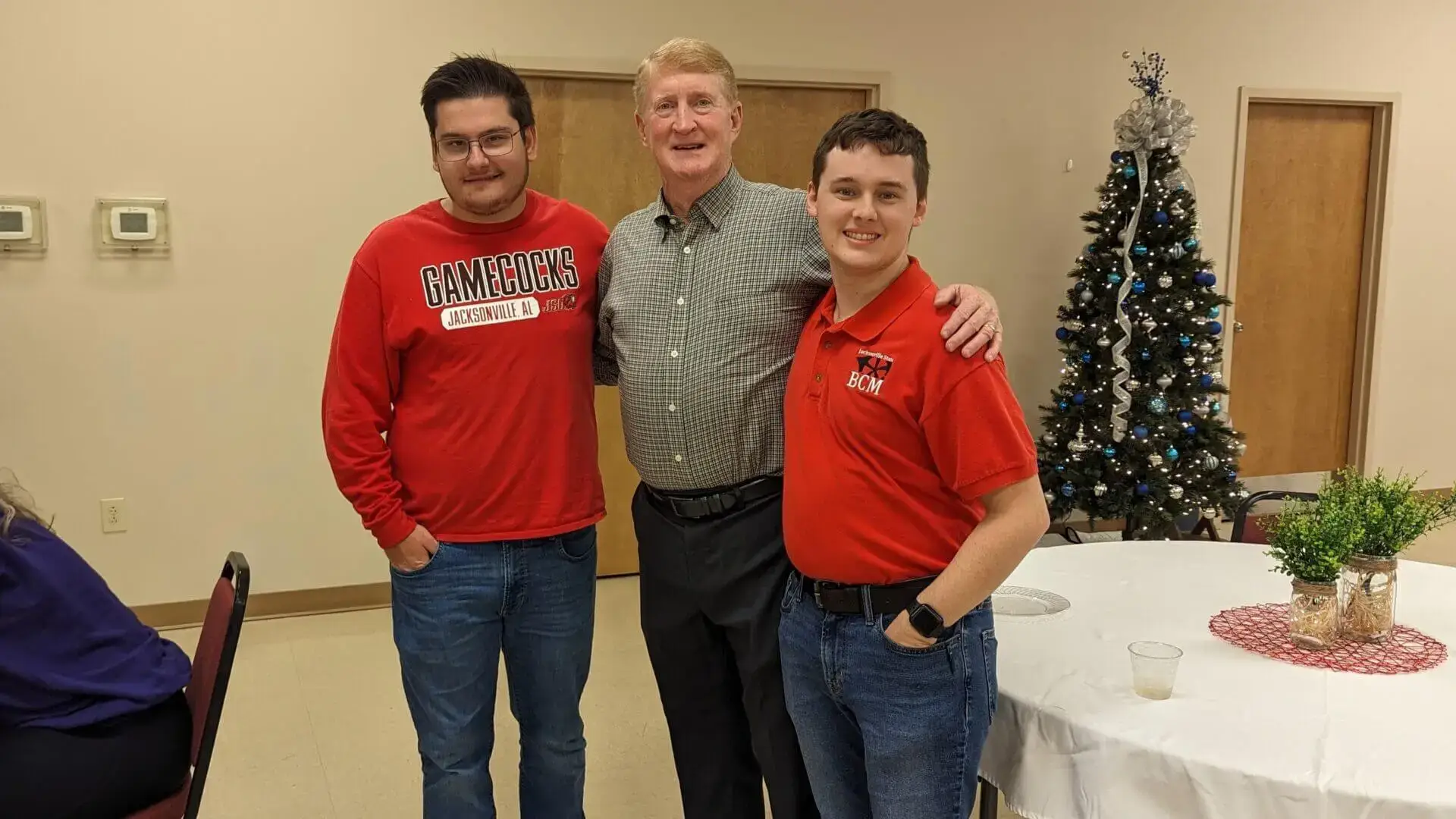 Jacksonville State University Baptist Campus Minister Gary Brittain poses with two college students