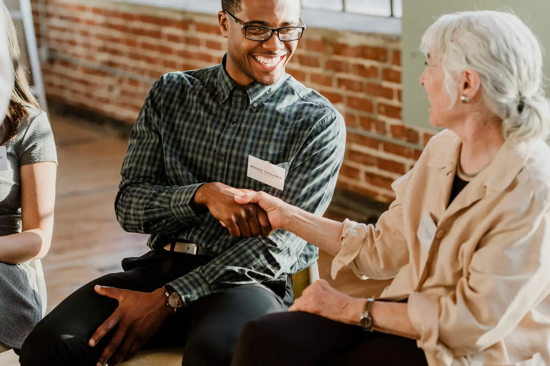 Young man and older woman shake hands