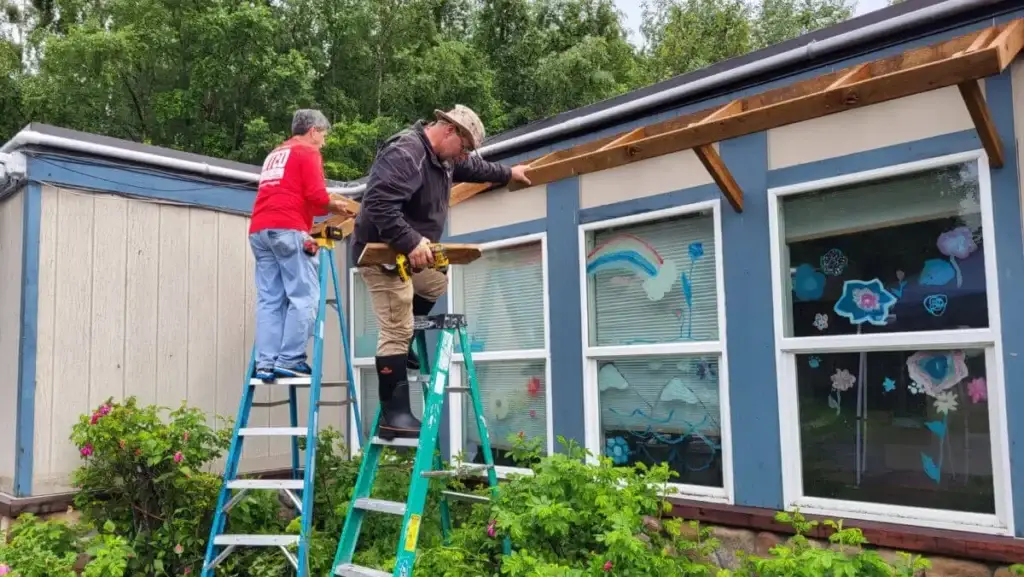 Volunteers from Montgomery Baptist Association work on an awning at Birchwood Behavioral Health