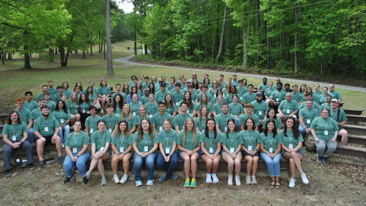 106 collegiate student missionaries pose for a picture wearing matching green shirts