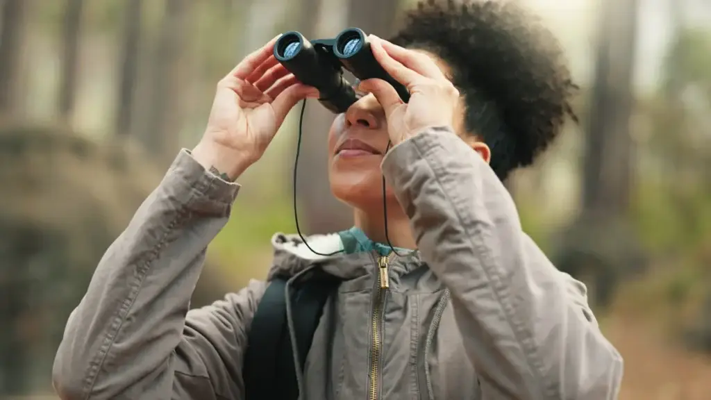 Woman with binoculars in a forest