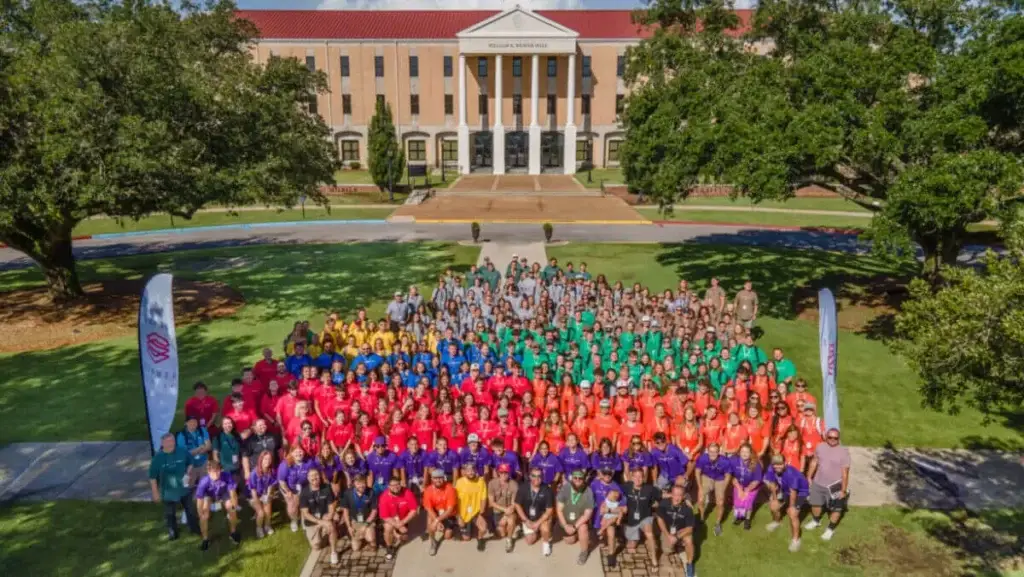 Students attending Super Summer Alabama pose in their different school color shirts