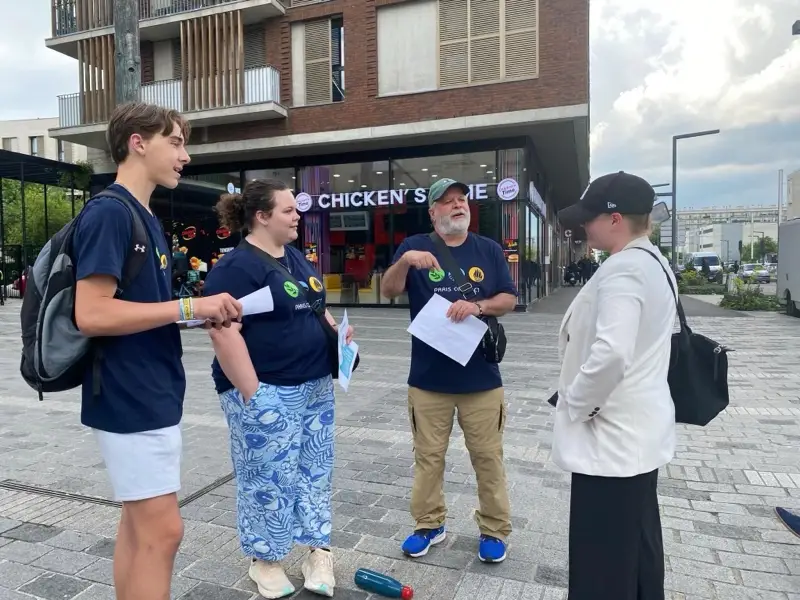 Summer missionaries share the gospel with a woman on the streets of Paris