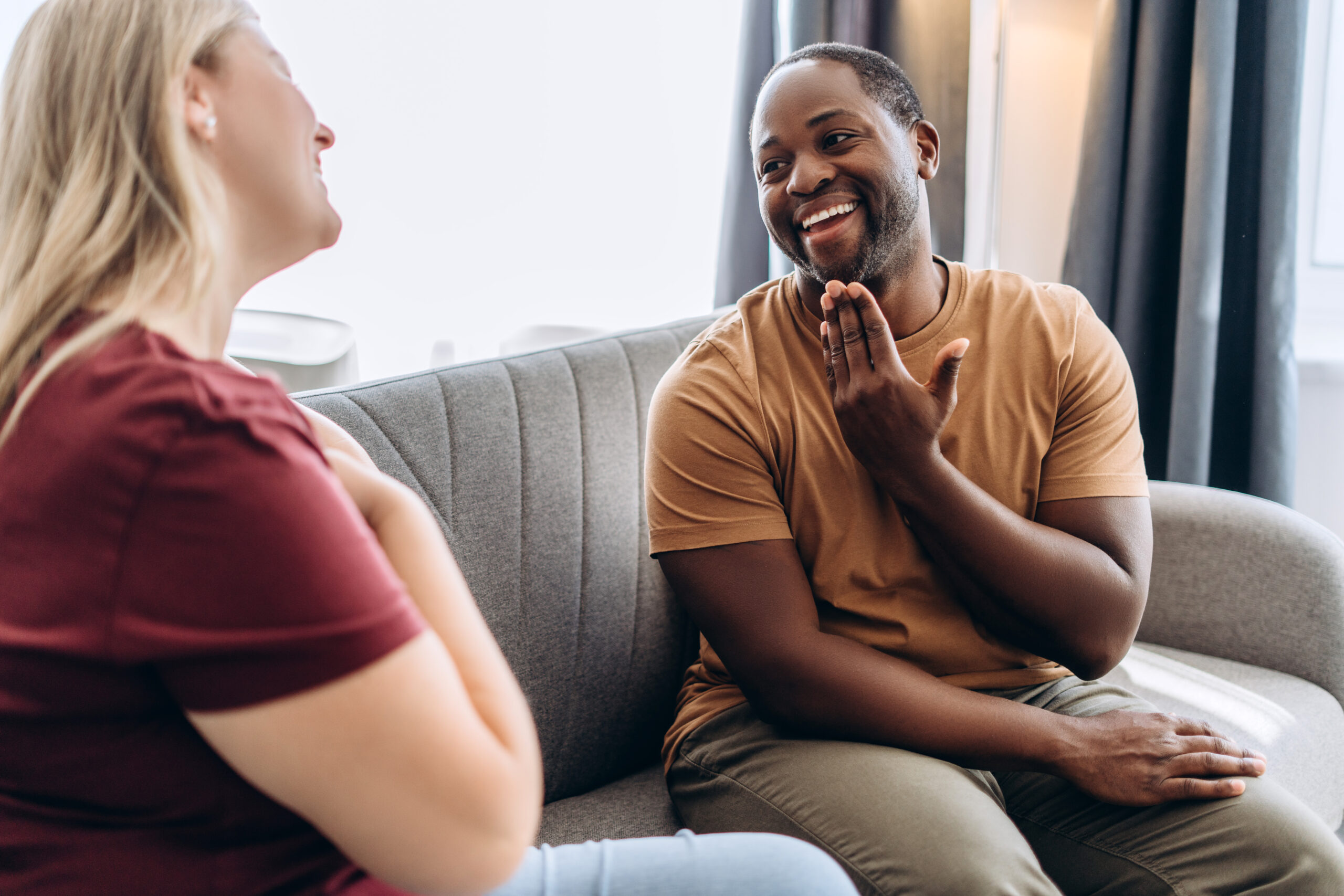 African American man and Caucasian woman speaking with deaf language at home