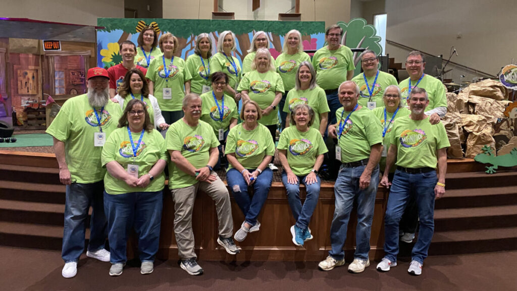 Group of VBS leaders pose for photo in green Magnify shirts